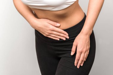 Karın ağrısı olan bir fitness kadınının yakın görüntüsü.