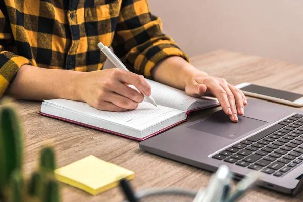 O estudo é poder. fechar as mãos de uma mulher de negócios, estudante ou freelancer em camisa amarela fazendo anotações em seu caderno — Fotografia de Stock