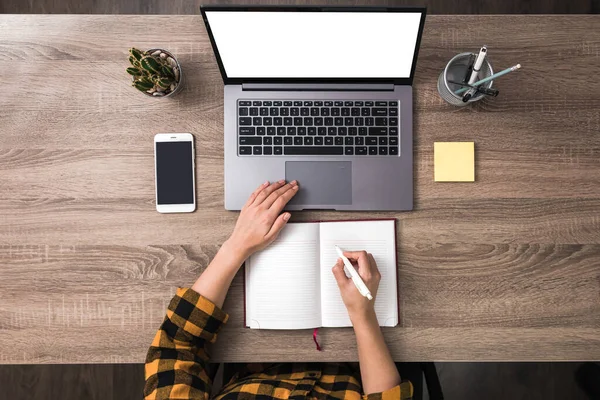 Vista superior mãos de uma mulher de negócios, estudante ou freelancer em camisa amarela usando tela branca laptop com e fazer anotações. tela branca — Fotografia de Stock