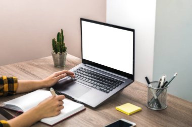 Bir iş kadınının, öğrencinin ya da serbest çalışanın ellerini sarı gömlekli ve dizüstü bilgisayarında beyaz ekranlı. modern ofis