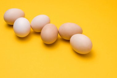 Sarı arkaplan üzerinde doğal ekolojik yumurtalar.