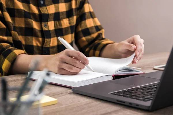 O estudo é poder. fechar as mãos de uma mulher de negócios, estudante ou freelancer em camisa amarela fazendo anotações em seu caderno — Fotografia de Stock