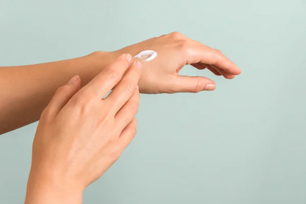 closeup of tender hands of a young woman with moisturizer on. spring skin protection