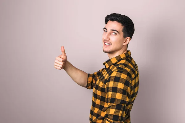Like it. handsome brunette young man showing big thumb up against pastel pink background — Stock Photo, Image