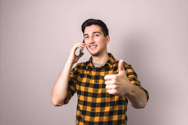 Satisfied client. man speaking on the phone showing big thumb up — Stock Photo, Image