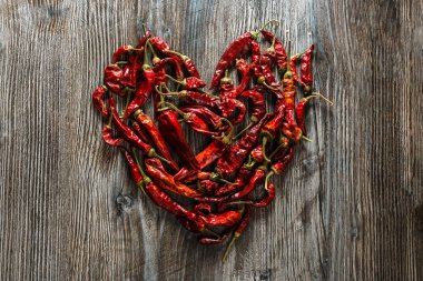 - Meksika yemeği. Ahşap arka planda kalp şeklinde kırmızı kırmızı kırmızı kırmızı biber. Baharatlı