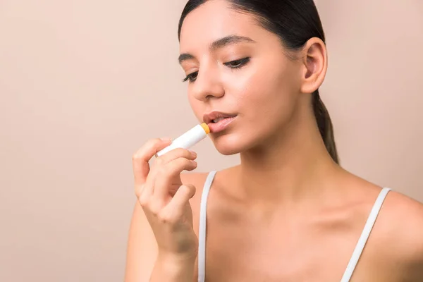 seasonal skin protection. woman applying lip protection balm.