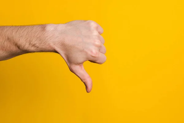 Není dobré a neschválené. zblízka nahoru ruka muže ukazující palec dolů nechutné znamení přes žluté pozadí s copyspace pro design — Stock fotografie