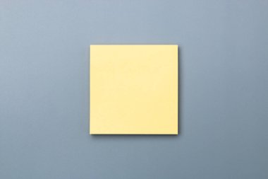 Metin kopyalama alanı eklemek için gri arkaplanda dramatik gölgesi olan sarı yapışkan not.