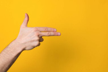 Adam, telif uzayı ile geniş sarı bir arkaplan üzerinde silah taklit