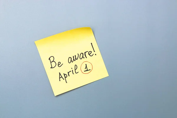 灰色の背景に黄色の付箋があることに注意してください 4月愚か者の日 — ストック写真