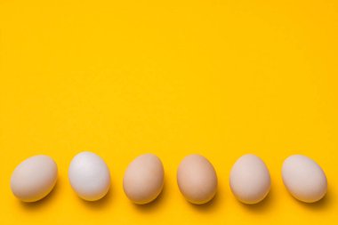 Sarı arkaplan üzerinde doğal ekolojik yumurtalar..