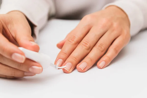 Fermer femme vernissage ongles à la maison. renforcement de l'ongle pendant la quarantaine — Photo