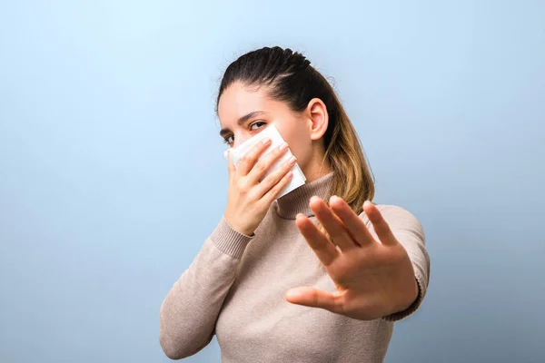 コロナウイルスの拡散を止めて。ナプキンをウイルス対策マスクとして手を挙げて青い背景に隔絶された距離を保ちたいと — ストック写真