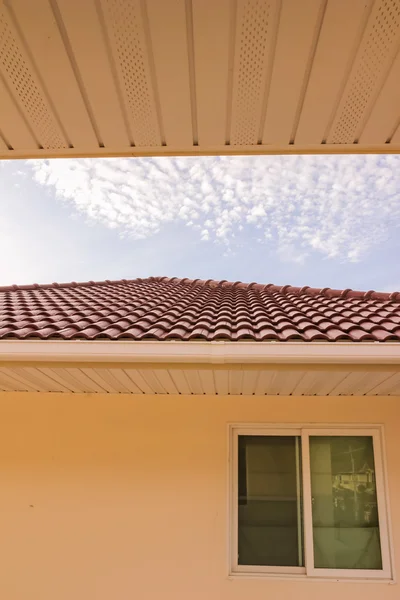 Dachówki, rynna i windows przeciw błękitne niebo — Zdjęcie stockowe