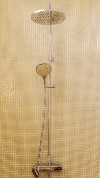 Rain shower in luxury bathroom with green mosaic tile