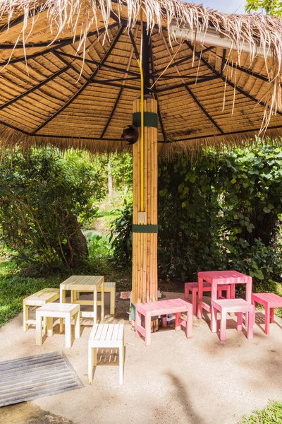 Creative thatched umbrellas with bamboo post in garden