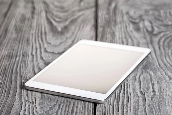 White tablet on a wooden table