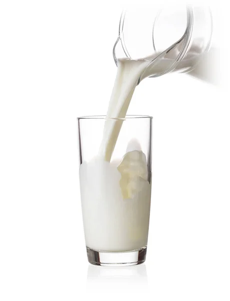 Gevulde glazen melk uit een kruik — Stockfoto