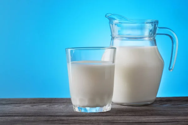 Jug and glass with milk on a wooden table — Stock Photo, Image