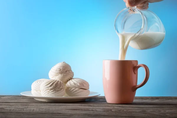 Milk poured from a jug into a cup — Stock Photo, Image