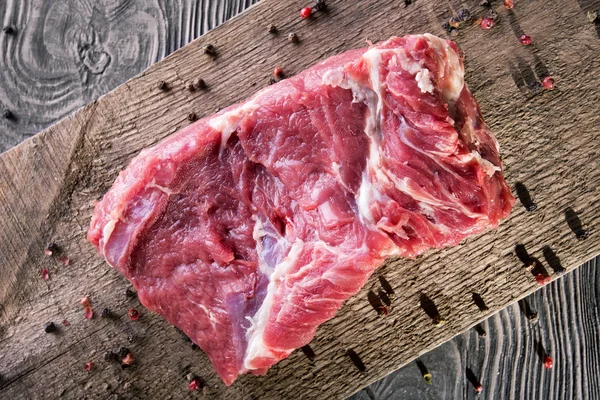 A piece of fresh raw meat with pepper — Stock Photo, Image