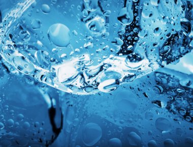 Damla bir buz küpü üzerinde yakın çekim vurdu