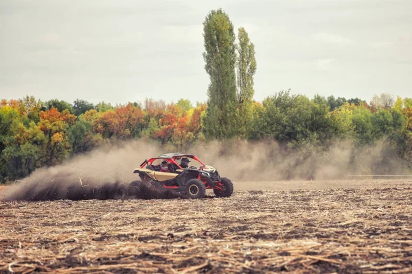 Quad bike on plowed field in the dust