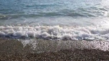 Dalgalar kıyıya inişli çıkışlı mavi deniz