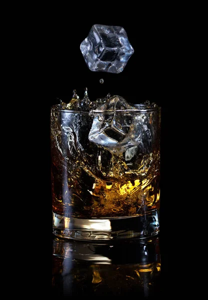 Cubos de hielo cayendo en un vaso de whisky — Foto de Stock