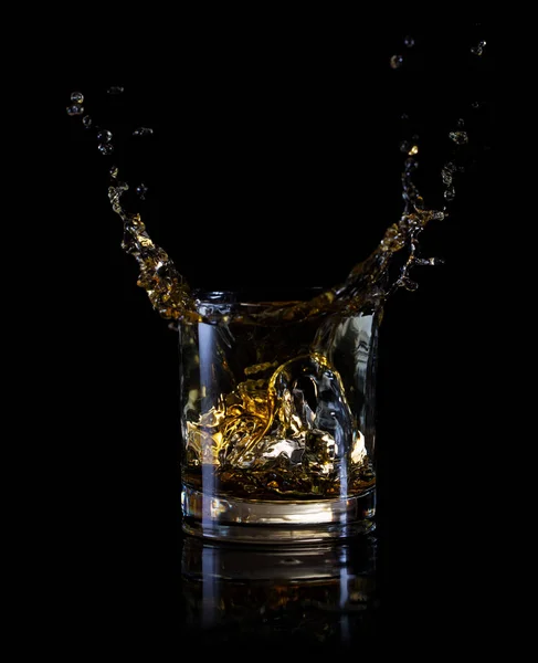 Splash of ice in a glass of whiskey — Stock Photo, Image