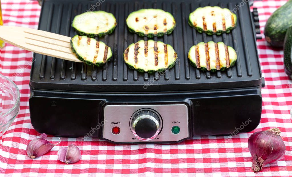 Sliced striped zucchini on electric grill