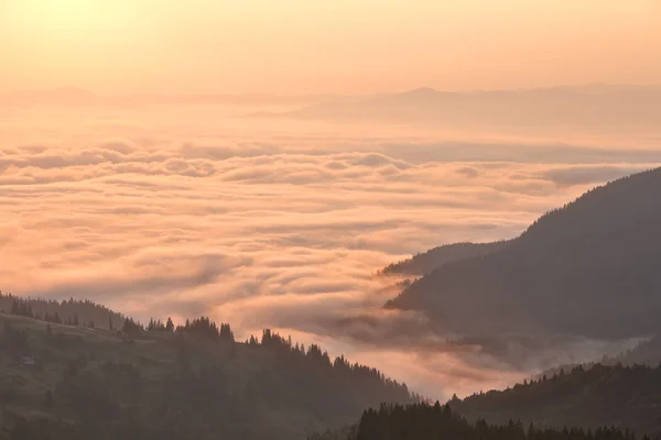 Nuvens nas montanhas ao nascer do sol — Fotografia de Stock