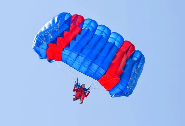 스카이다이버는 푸른 하늘에서 낙하산을 타고 내려간다 — 스톡 사진