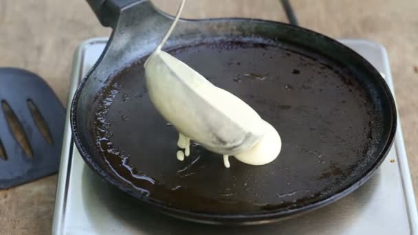 Pouring dough for a pancake on pan — 비디오