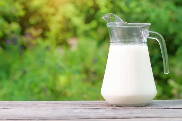 Jug of milk on a wooden table — Stock Photo, Image