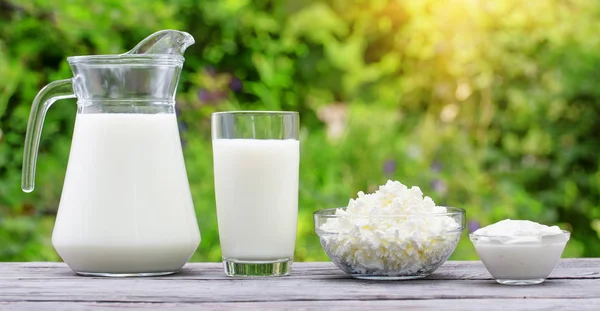 Milk curd and sour cream on a wooden table — Stock Photo, Image