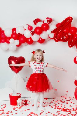 Sevgililer Günü. Süslü bir stüdyoda küçük tatlı bir kızın portresi. Aşk tanrısı gibi giyinmiş güzel küçük kız