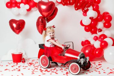 Sevgililer Günü. Süslü bir stüdyoda küçük tatlı bir kızın portresi. Aşk tanrısı gibi giyinmiş güzel küçük kız