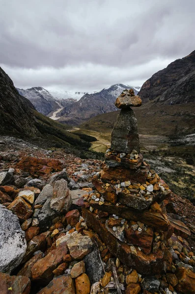 Alpamayo ana kampı yakınlarındaki quebrada santa cruz de peru 'nun arka planında bir çığ kalıntısı ile ön planda taş yığını.