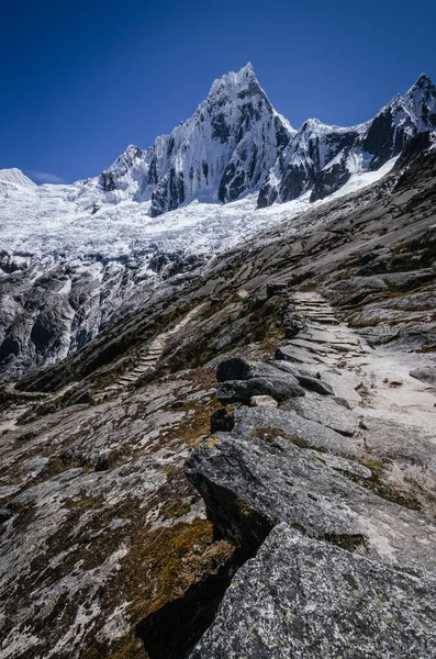 Peru 'daki quebrada santa cruz' da yüksek karlı bir dağ olan Taulliraju 'ya giden kayalık yol.