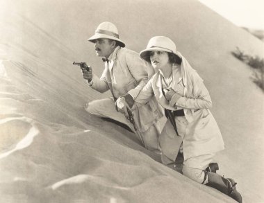  couple climbing up sand dune clipart
