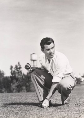 Golf topu tutan adam