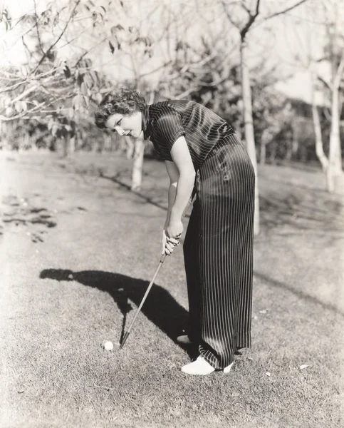 Egy nő golfozik a pályán. — Stock Fotó