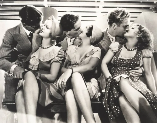 Couples kissing on table — Stock Photo, Image