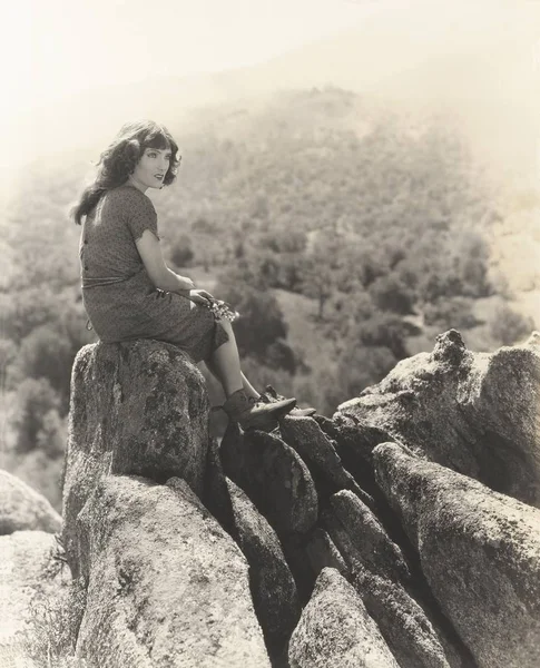 Žena sedící na skále — Stock fotografie