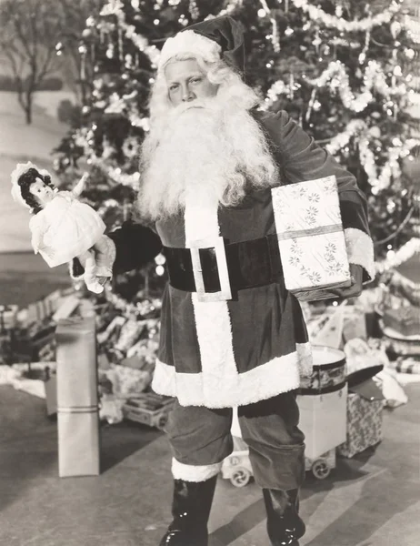 Santa Claus står med gåvor — Stockfoto