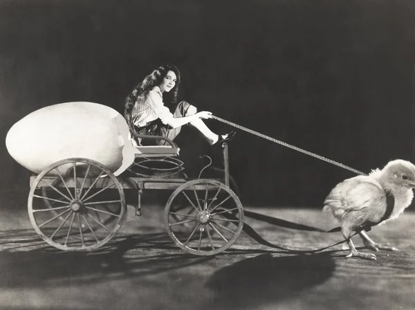 Chick pulling cart with woman — Stock Photo, Image
