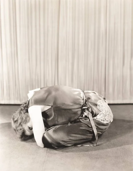 Traurige junge Frau beugt sich, während sie zu Hause auf dem Boden sitzt — Stockbild Frau beugt sich im Sitzen auf dem Boden — Stockfoto