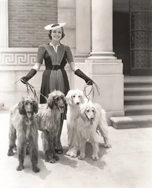 Mujer con perros de pie fuera — Foto de Stock